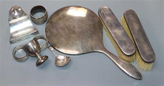 A George III silver caddy spoon, pair of silver clothes brushes and hand mirror, ink well, egg cup, 3 napkin rings.